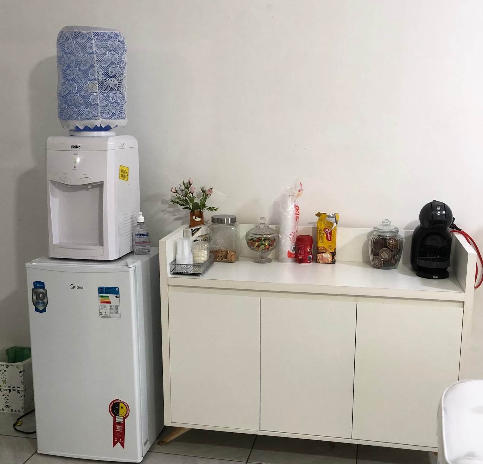Cantinho do café do studio, com cafeteira e doces para as clientes